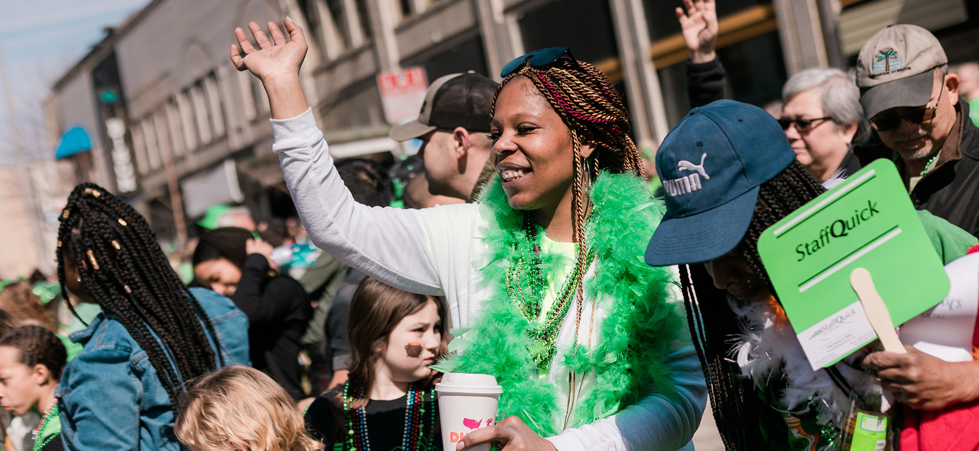 A woman stands in a crowd waving