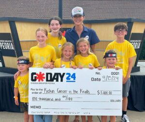 A group of children holding a large check