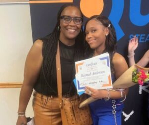 A person holding a certificate and smiling